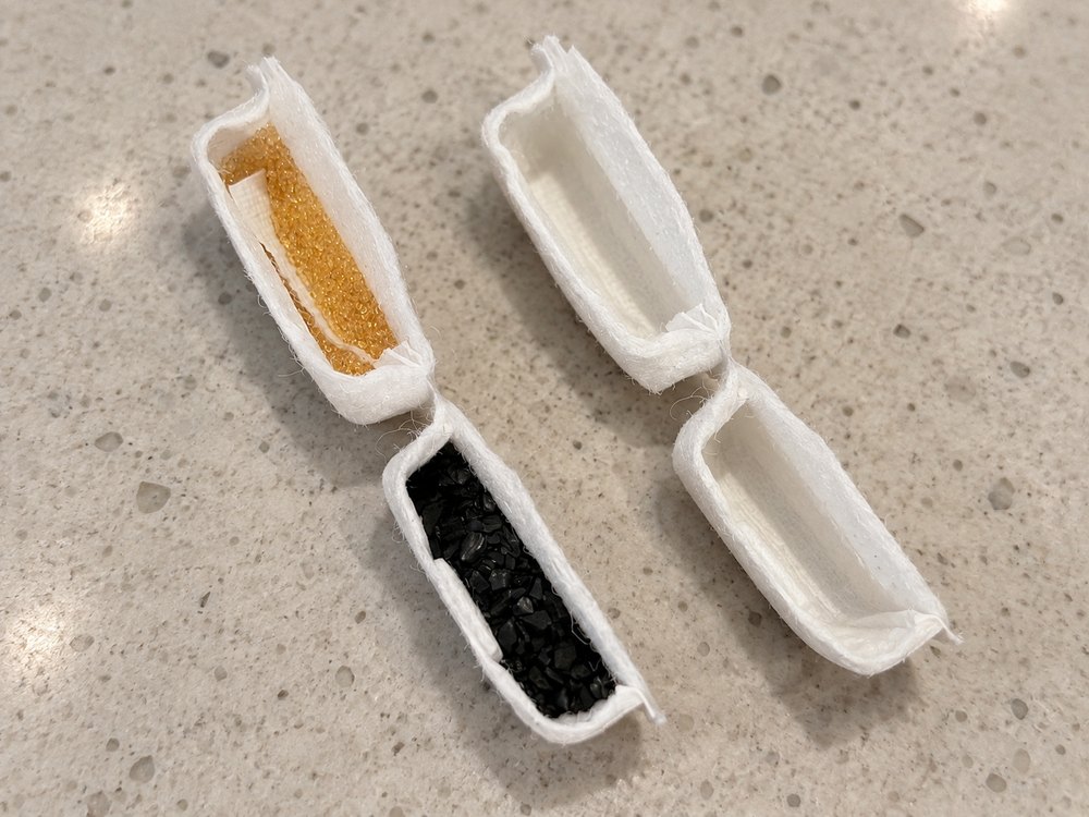 Two filter cartridges cut open side by side: one packed with activated carbon and ion-exchange resin, the other containing only cotton wadding